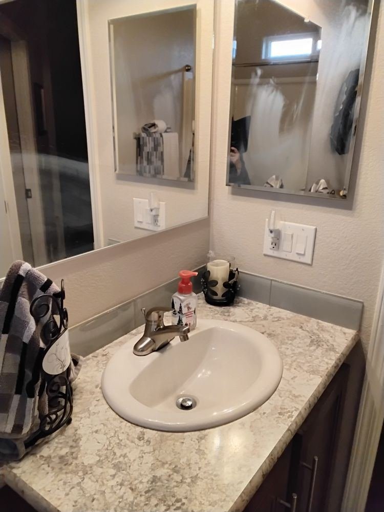 A spotless bathroom sink and polished mirror after a clean