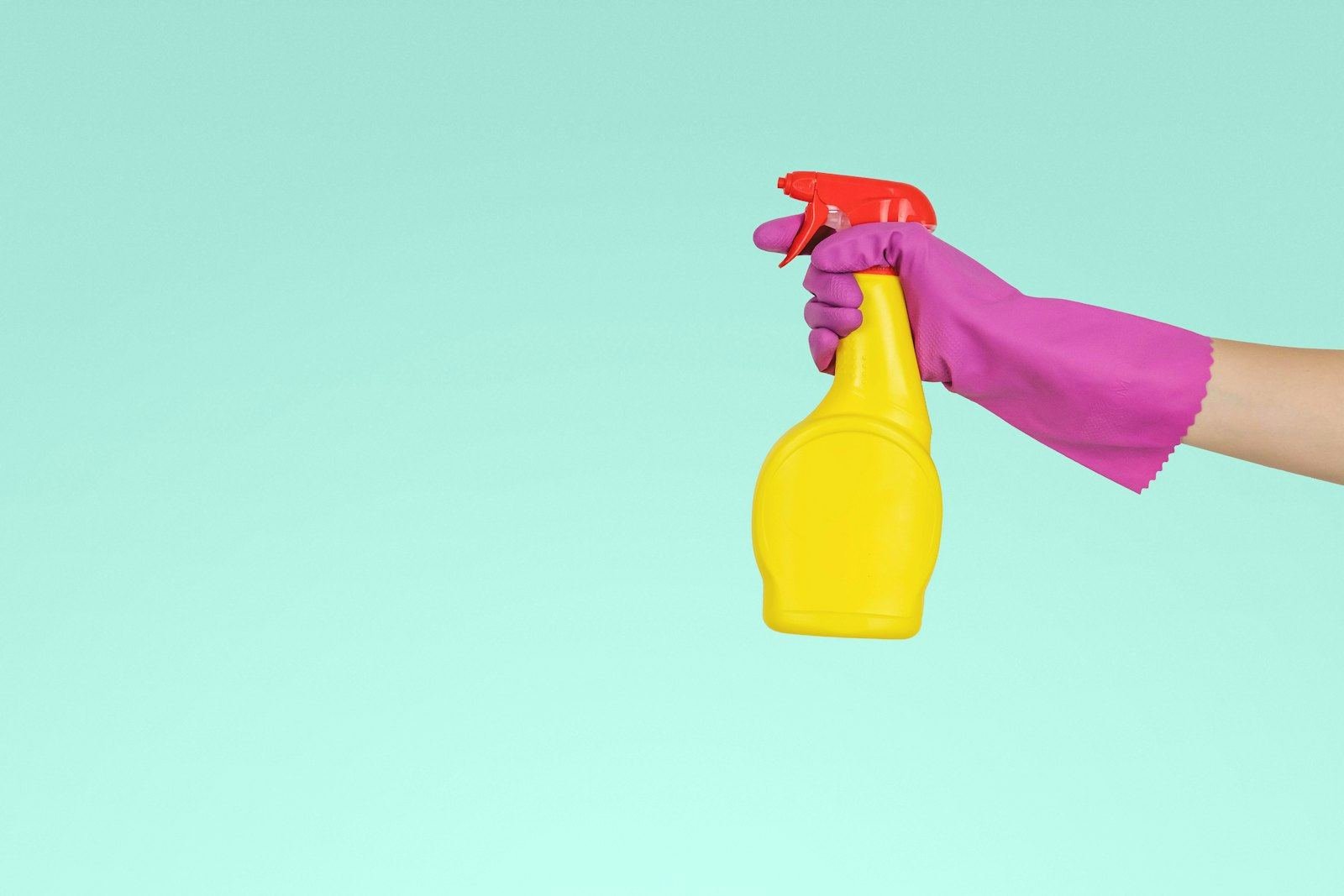 A gloved hand cleaning with a spray bottle